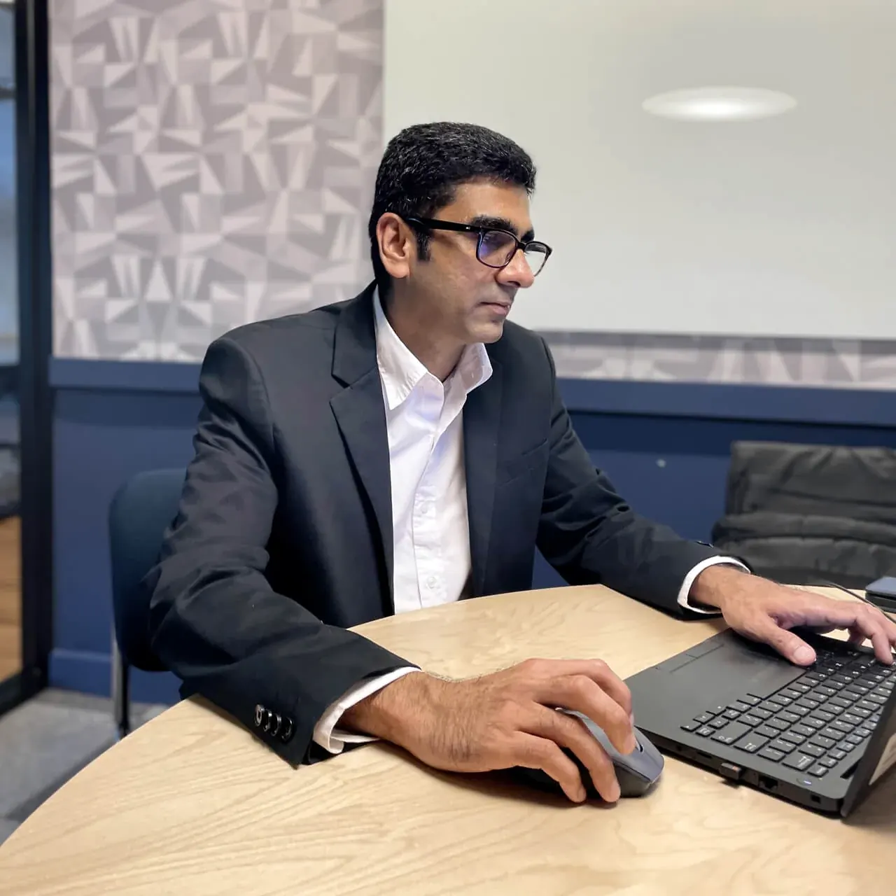 Binu Gopinath of Tomegan Marketing Group working at a laptop